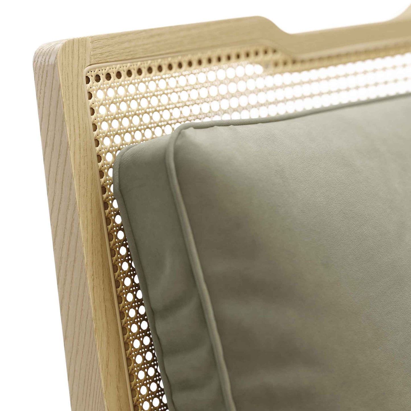 Close up of pale modern wood frame rattan chair with velvet upholstered cushions in sage green.