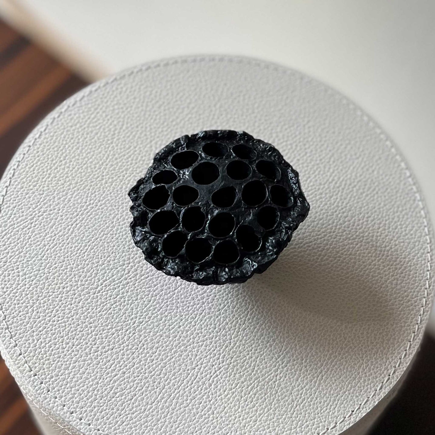 Close up of light cream leather cylinder box with cast brass handle