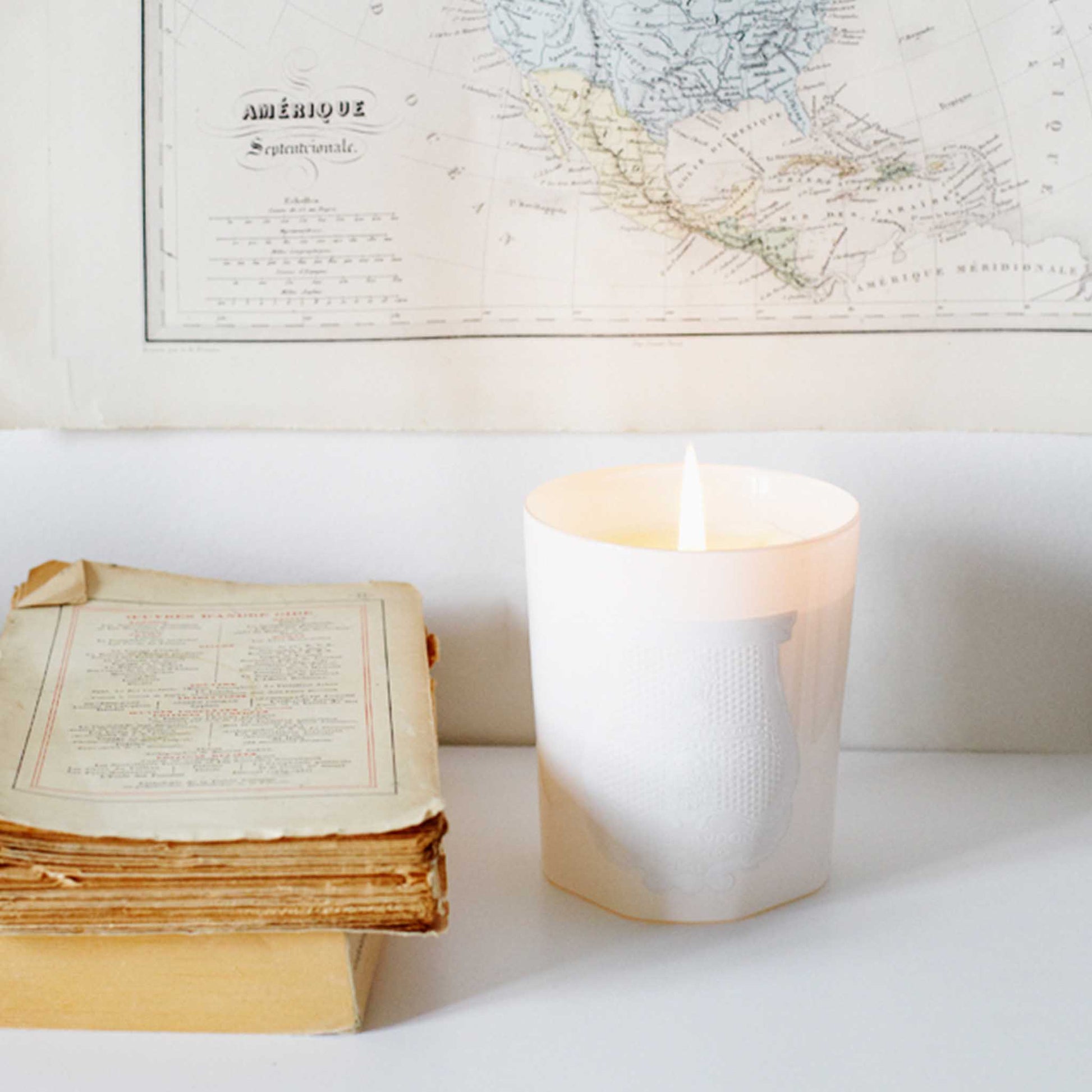 lifestyle shot of a lit cire trudon white candle