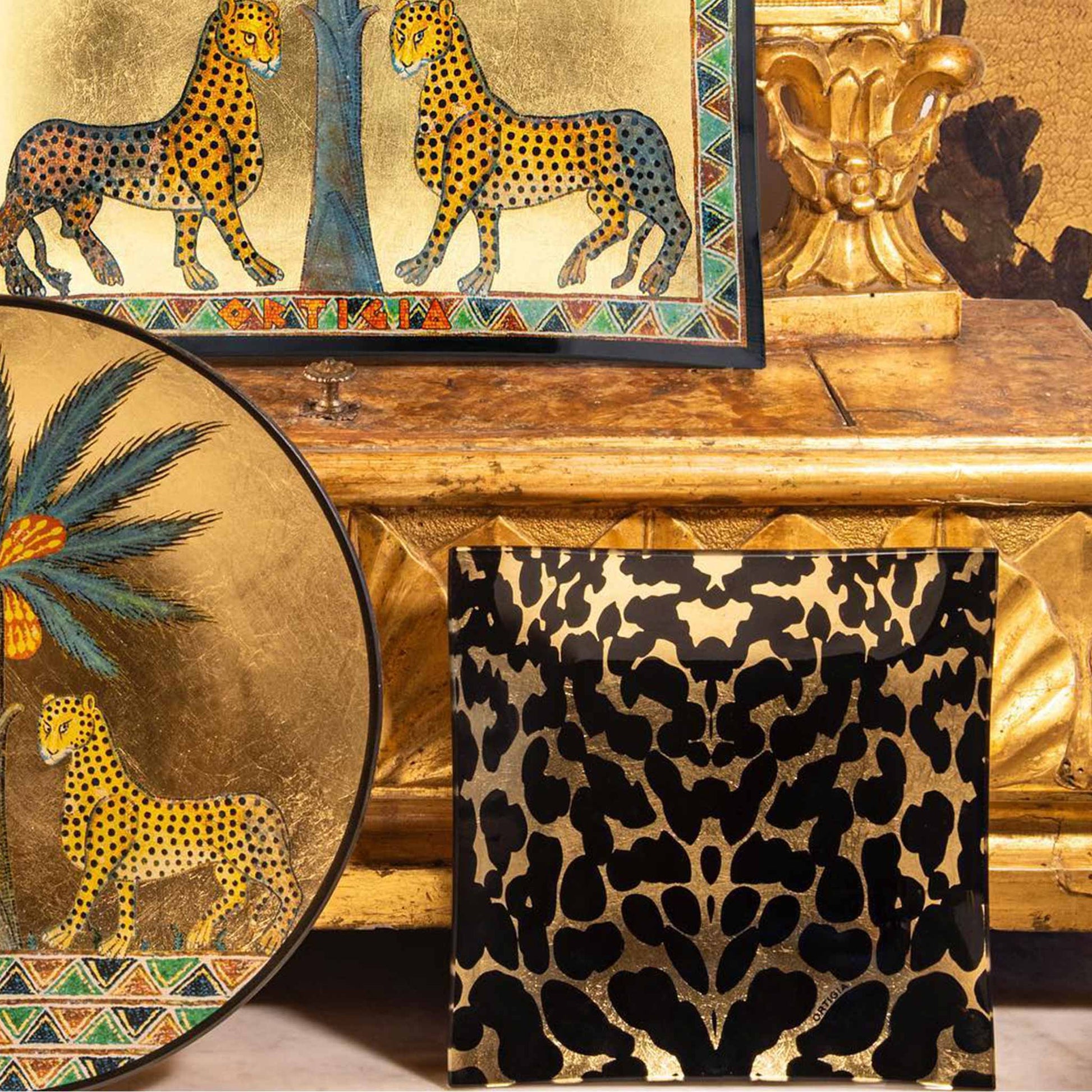 Lifestyle image of leopard print glass plate with gold leaf. Displayed with other gold accessories.