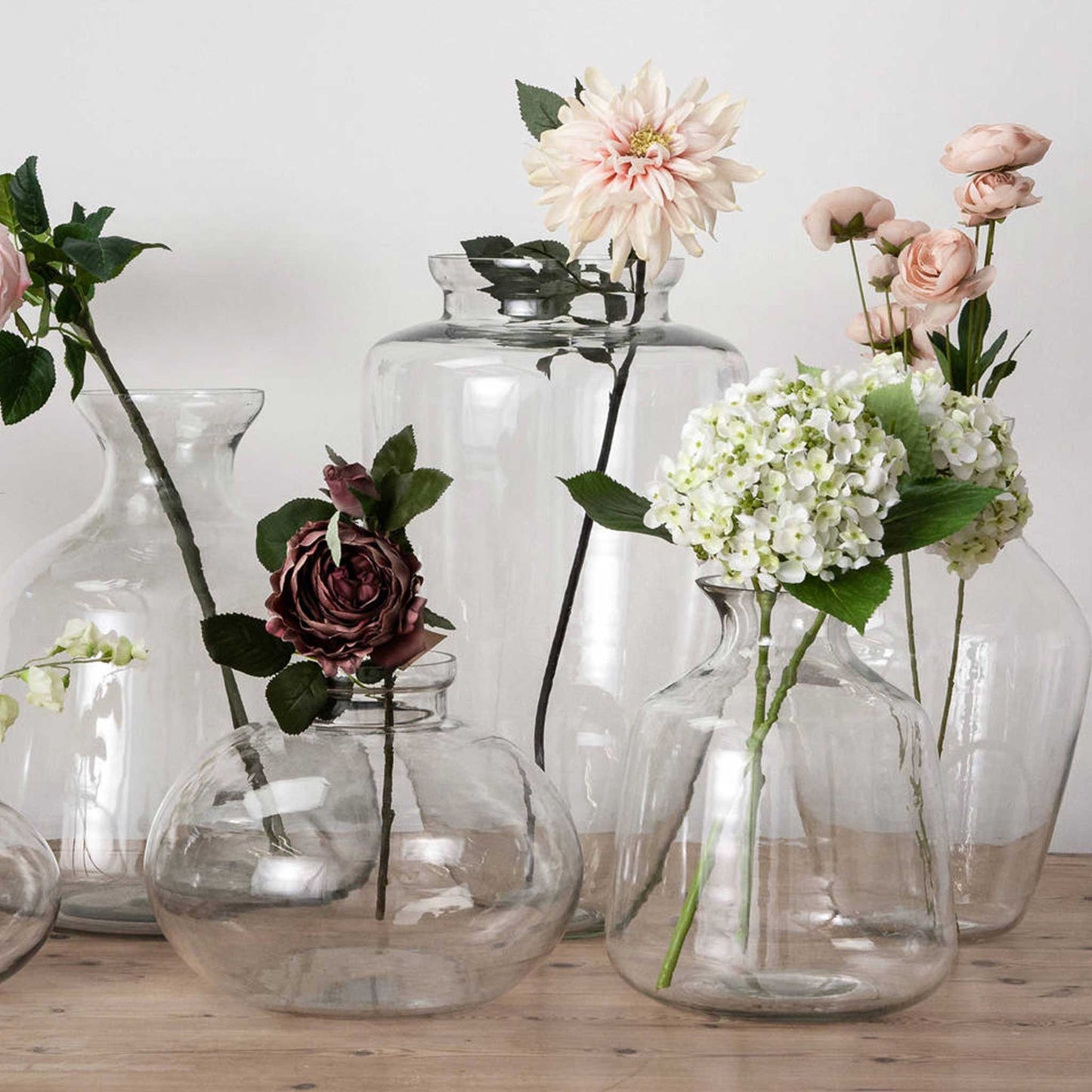 Lifestly image of collection of glass vases with single flower stems