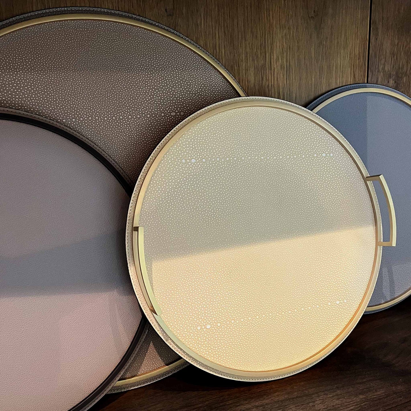 Collection of round textured Italian leather trays with brass handles