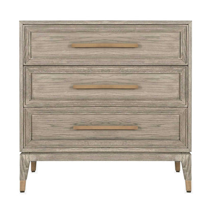 Light oak chest of three drawers with long brass handles and brass feet