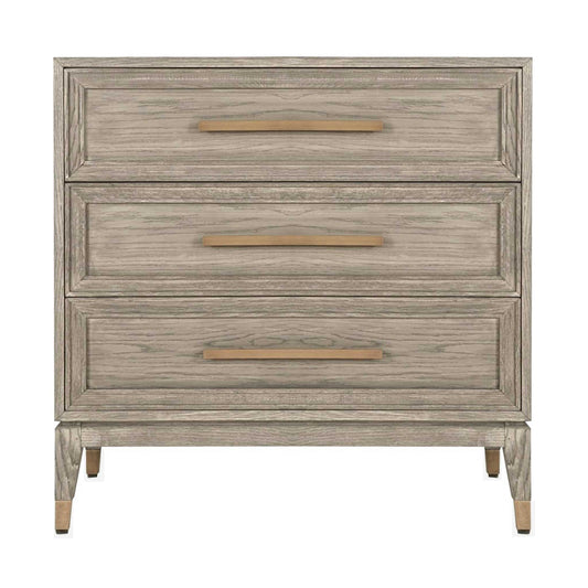 Light oak chest of three drawers with long brass handles and brass feet